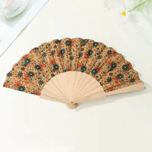 Decorative floral-patterned hand fan on table.